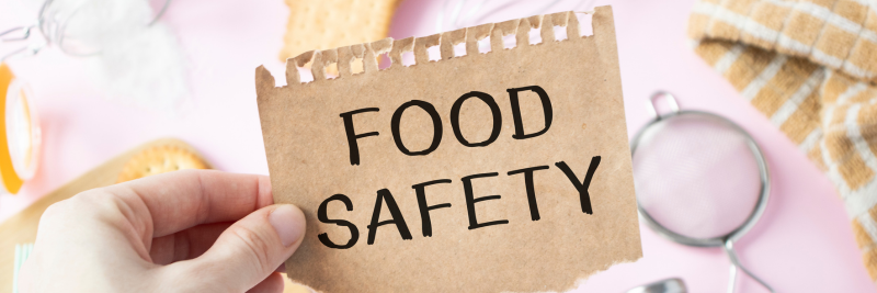 image of hand holding a sign saying food safety