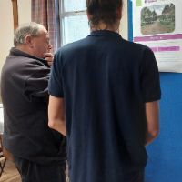 two men looking at notice board